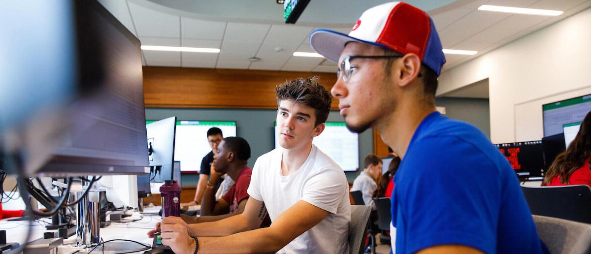 巴尼 students having a discussion at the trading lab